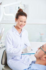 Female dentist consulting with patient