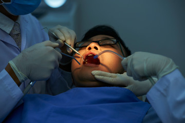 Dentists treating teeth of patient