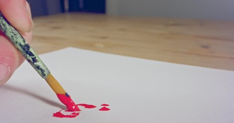 Macro shot of brush painting on paper with acrylic colors