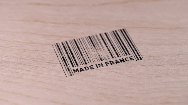 Man puts bar code print on wooden box, made in France