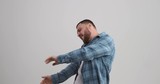 Stylish young man dancing over white background