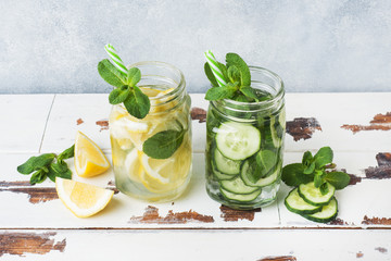 Detox water for healthy lifestyle. Fresh water in jar with lemon, cucumber and mint on wooden table.