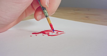 Macro shot of brush painting on paper with acrylic colors
