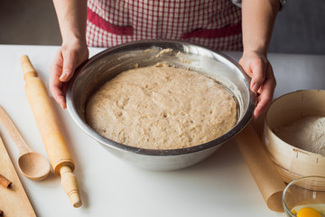 Fototapeta premium Woman kneading dough on kitchen table