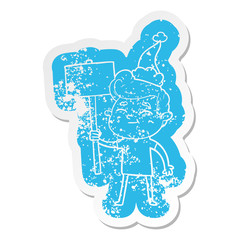 happy cartoon distressed sticker of a man with sign wearing santa hat