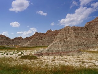 Fototapeta na wymiar Green prairie lands and amazing rock formations at the Badlands National Park in South Dakota, USA.