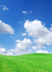 Idyllic view, green hills and blue sky with white clouds