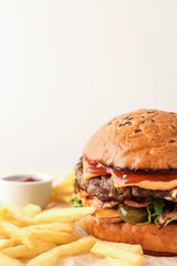 Tasty burger and french fries on table, closeup