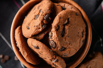 Tasty cookies with chocolate chips in bowl, closeup