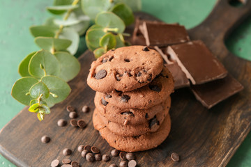 Tasty cookies with chocolate chips on wooden board, closeup