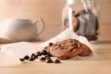 Tasty cookies with chocolate chips on wooden table