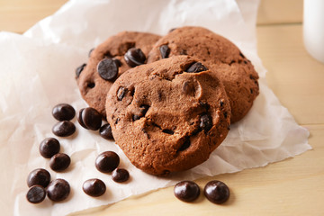 Tasty cookies with chocolate chips on wooden table