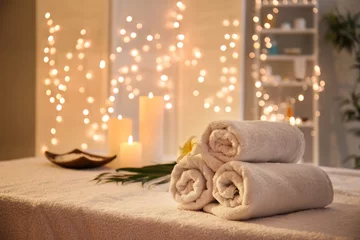 Tuinposter Rolled towels on table in spa salon © Pixel-Shot