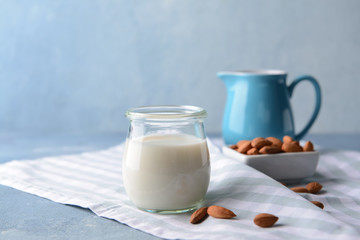 Glass jar of healthy almond milk on table