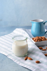 Glass jar of healthy almond milk on table