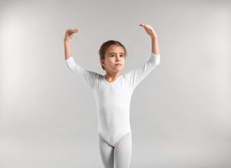 Cute little ballerina on light background