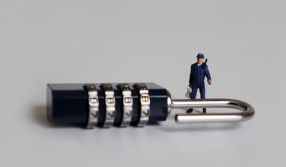 A combination lock and a miniature man standing with a loudspeaker.