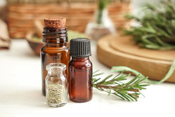 Bottles with rosemary oil on table
