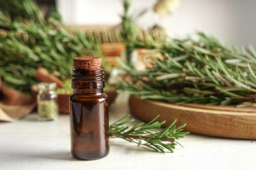 Bottle with rosemary oil on table