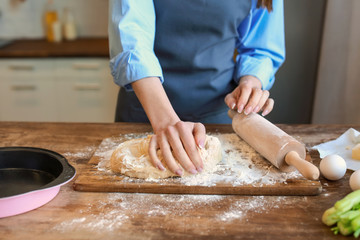 Obraz na płótnie Canvas Beautiful woman making dough in kitchen at home
