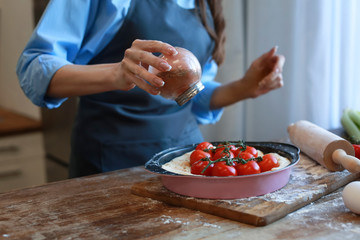 Beautiful woman cooking vegetable pie in kitchen at home