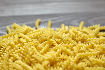 Italian spiral pasta on brown wooden table