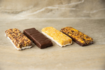 Various muesli bars on marble stone background