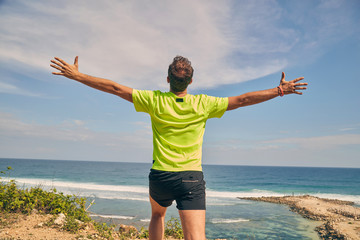Sportsman on a tropical exotic cliff near the ocean.