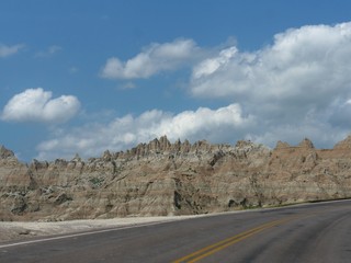 Clouds meet the sharp tips of the rock formations at the Badlands National Park in South Dakota, USA