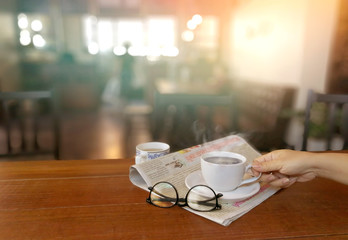 People drinking hot coffee and reading newspaper