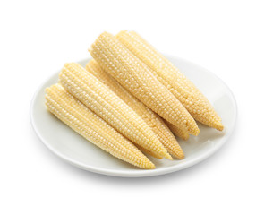 Plate with baby corn cobs on white background