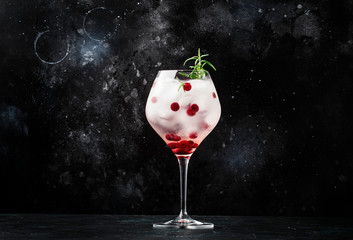 Cranberry cocktail with ice, rosemary and berries in big wine glass, bar tools, gray bar counter background, top view - obrazy, fototapety, plakaty