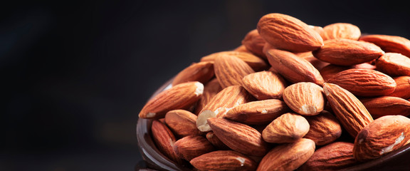 Freash almond in bowl on kithcen table, close up, banner with place for text, selective focus