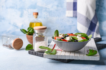Healthy salad with feta cheese on light table