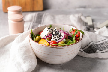 Healthy salad with feta cheese on grey table