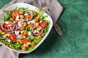 Healthy salad with feta cheese on color table