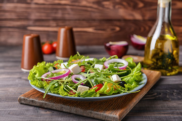 Healthy salad with feta cheese on wooden table