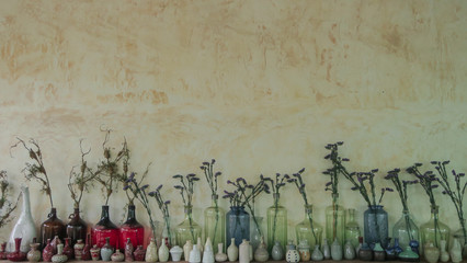 Dried flower in the bottle with in wall background.