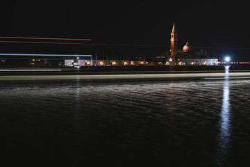 Fototapeta premium Venice canal with historical buildings and gondolas at night. Italy.
