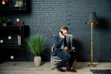businessman sitting on the floor and talking on mobile phone