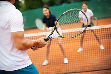 Group of healthy happy friends at the club playing tennis