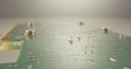 Extreme macro dolly shot of a PCB computer board with capacitors and transistors