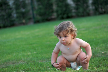 Baby getting wet on a garden in summer