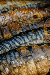 BBQ, grill, kebab. Mackerel fish strung on wooden sticks and tied with string. Close-up.