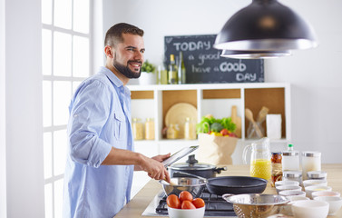 Smiling and confident chef standing in large kitchen