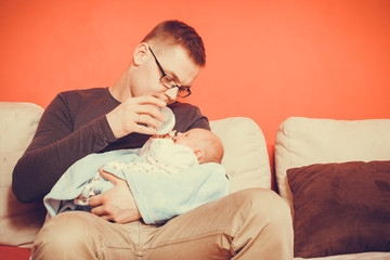 Father feeding from bottle newborn baby