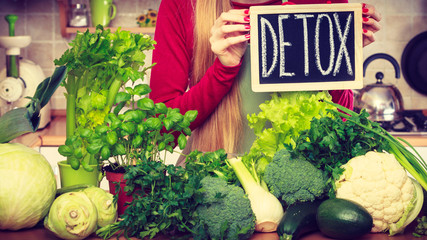 Woman having green diet vegetables, detox sign