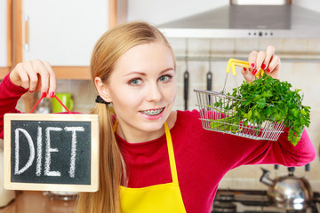 Woman holding diet sign and shopping basket with