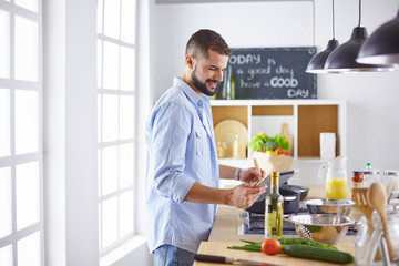 Smiling and confident chef standing in large kitchen