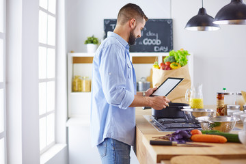 Smiling and confident chef standing in large kitchen